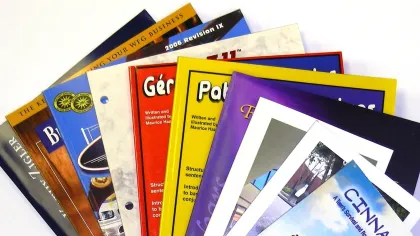 A colorful assortment of brochures and booklets stacked together showcasing various designs and titles.