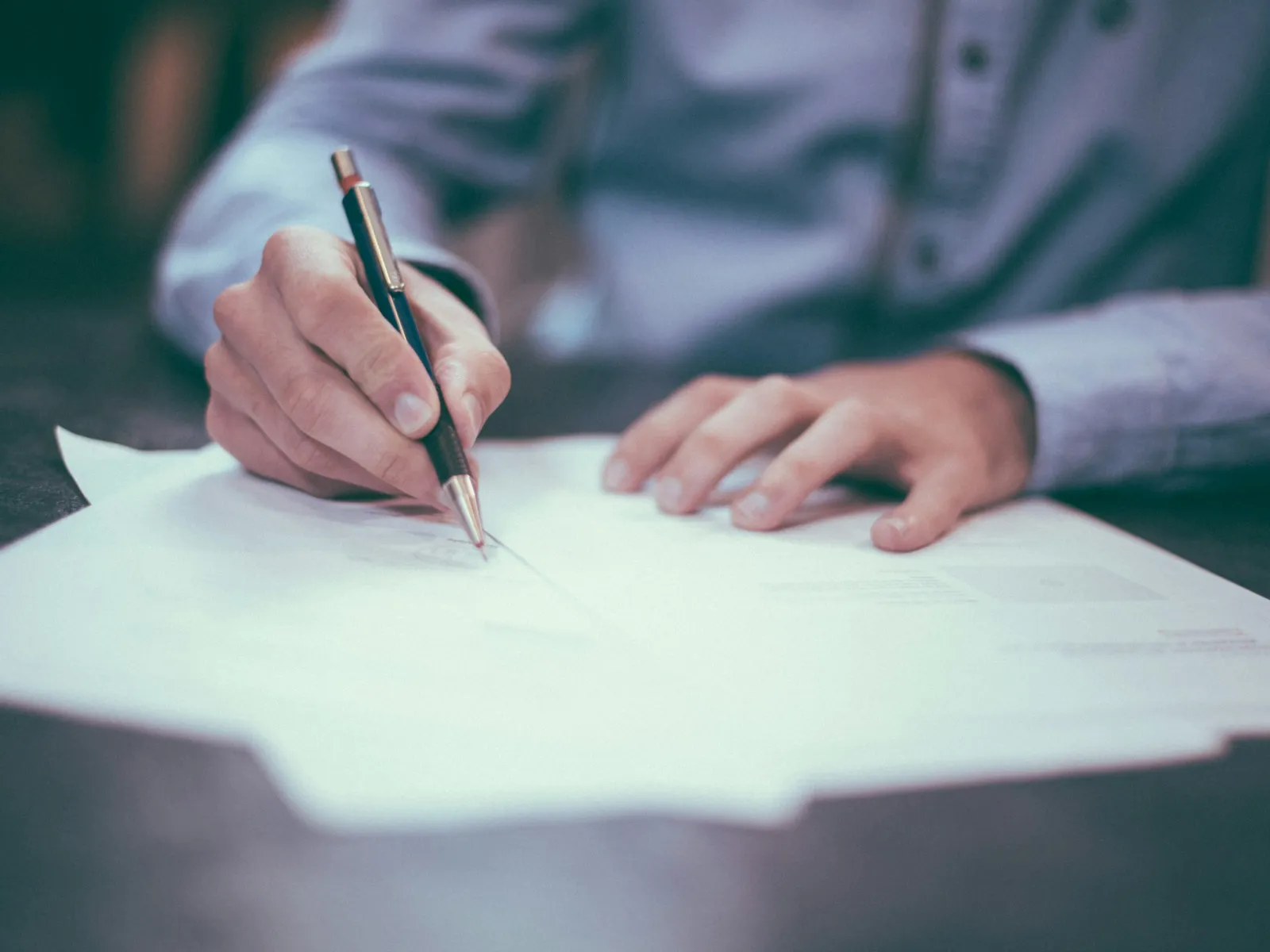 a person writing on a piece of paper